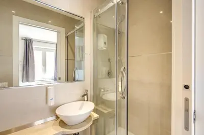 a bathroom with a toilet and a glass shower at Aurelia Vatican Suites in Rome