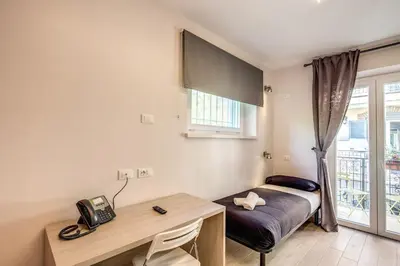a room with a desk and a telephone and a window at Aurelia Vatican Suites in Rome