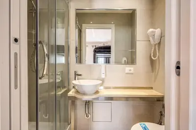a bathroom with a sink and a glass shower at Aurelia Vatican Suites in Rome