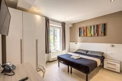 a bedroom with a bed and a tv and a table at Aurelia Vatican Suites in Rome