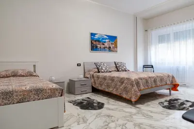 a white bedroom with two beds and a window at locazione turistica via dei savorelli 120 in Rome