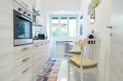 a kitchen with white cabinets and a table and a television at locazione turistica via dei savorelli 120 in Rome