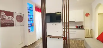 a kitchen with white cabinets and a tv on a wall at Vatican Apartment St. Peter in Rome