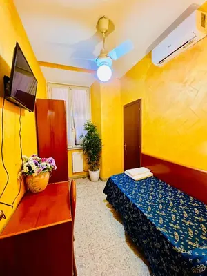 a small room with a blue bed and yellow walls at Hotel Casali in Rome
