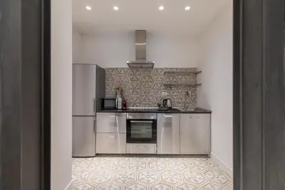 a kitchen with stainless steel appliances and a tile floor at iFlat Trastevere Unique Loft in Rome