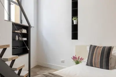 a living room with a staircase and a bed at iFlat Trastevere Unique Loft in Rome