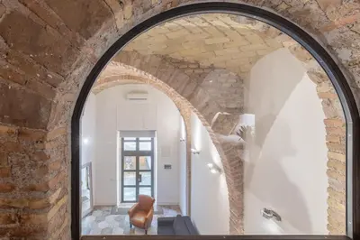 an arched doorway in a brick wall with a mirror at iFlat Trastevere Unique Loft in Rome