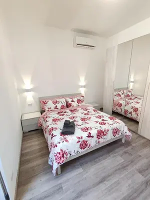 a bedroom with a bed with a red and white blanket at Lotto 30 Metro Garbatella in Rome
