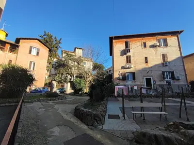 a bench in a courtyard between two buildings at Lotto 30 Metro Garbatella in Rome