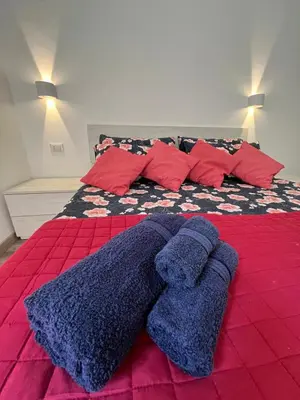 a bed with blue blankets and pillows on it at Lotto 30 Metro Garbatella in Rome