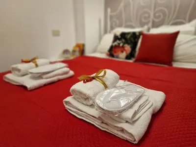 three towels on a bed with a red blanket at Giuditta San Pietro 52 Loft Roma in Rome