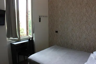 a small bedroom with a bed and a window at Rooms Piramide in Rome