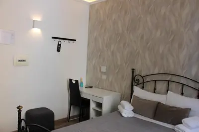 a hotel room with a bed and a desk and a desk at Rooms Piramide in Rome