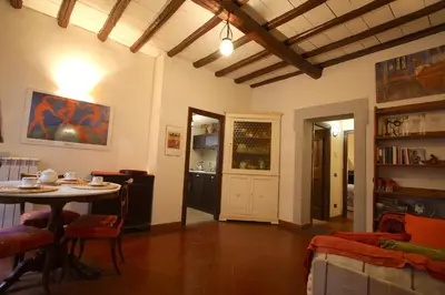 a living room with a table and a dining room at Pozzuolo Holiday House in Rome