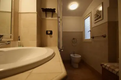 a bathroom with a tub and a toilet and a sink at Pozzuolo Holiday House in Rome