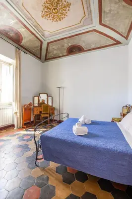 a bedroom with a blue bed with a ceiling at CHARMING APARTMENT AT SPANISH STEPS, no elevator in Rome