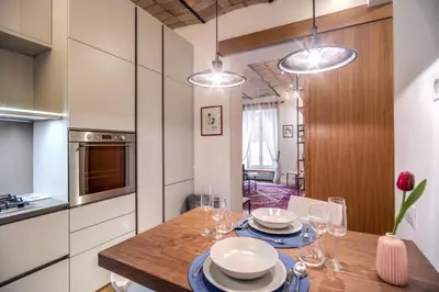 a kitchen with a wooden table with plates and wine glasses at PgrHome Borgo Vittorio in Rome