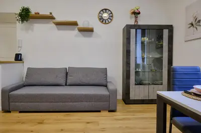 a couch in a living room with a clock on the wall at Testaccio Guest House in Rome
