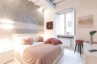 a white bedroom with a bed and a window at Manara 57 Dream Apartment Trastevere in Rome