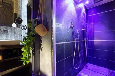 a purple shower with a person taking a picture at Manara 57 Dream Apartment Trastevere in Rome