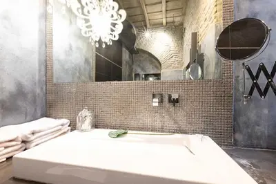 a bathroom with a large white sink and a mirror at Manara 57 Dream Apartment Trastevere in Rome