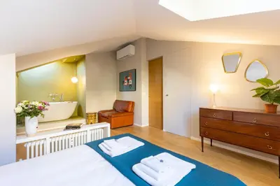 a bedroom with a bed and a tub and a sink at Rome As You Feel - Luxury Terrace in Navona in Rome