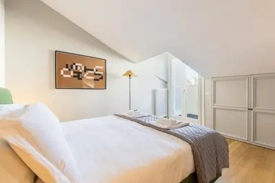 a white bedroom with a large bed and a window at Rome As You Feel - Luxury Terrace in Navona in Rome