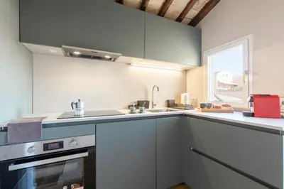 a kitchen with white cabinets and a sink and a window at Rome As You Feel - Luxury Terrace in Navona in Rome