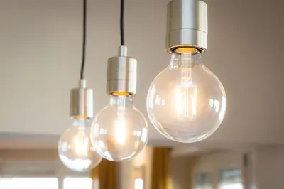 a group of light bulbs hanging from a ceiling at AURELIA SUNSET PENTHOUSE by Rental in Rome in Rome
