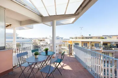 a patio with two tables and chairs on a balcony at AURELIA SUNSET PENTHOUSE by Rental in Rome in Rome
