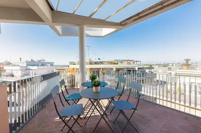 a patio with a table and chairs on a balcony at AURELIA SUNSET PENTHOUSE by Rental in Rome in Rome