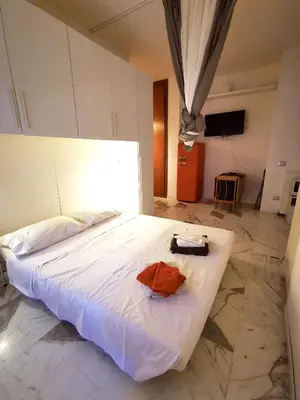 a small bedroom with a bed and a kitchen at Rouge Studio - 10 min from Vatican in Rome