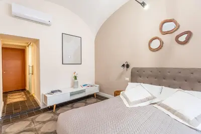 a white bedroom with a bed and a mirror at Daplace - Lucia Apartment in Rome