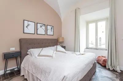 a bedroom with a bed with white sheets and a window at Daplace - Lucia Apartment in Rome