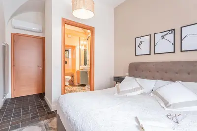 a bedroom with a large bed and a bathroom at Daplace - Lucia Apartment in Rome