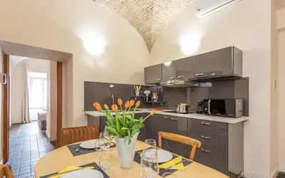 a kitchen with a table with orange flowers on it at Daplace - Lucia Apartment in Rome