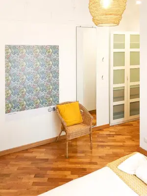 a wicker chair with a yellow pillow sitting in a room at Testaccio B45 Guesthouse in Rome