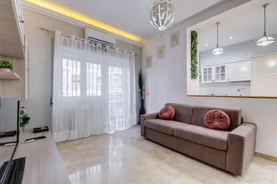 a living room with a couch and a kitchen at JMartins Vatican suites in Rome