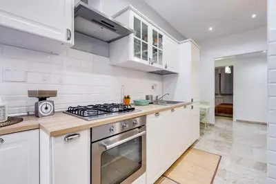 a kitchen with white cabinets and a stove top oven at JMartins Vatican suites in Rome