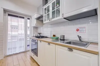 a kitchen with white cabinets and a sink at JMartins Vatican suites in Rome