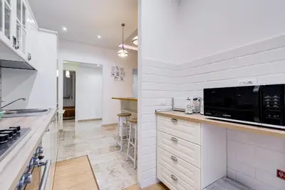 a kitchen with white cabinets and a microwave at JMartins Vatican suites in Rome
