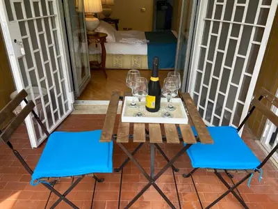 a table with a bottle of wine and two chairs at Vicario138 in Rome