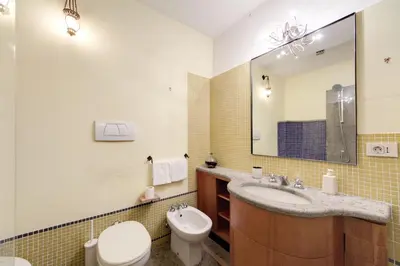 a bathroom with a sink and a toilet and a mirror at The Smart Loft in Rome