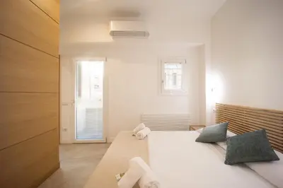 a bedroom with a large white bed and a window at Casa Camilla in Rome