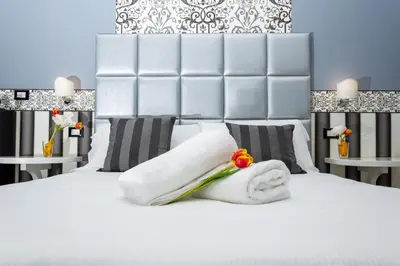a bedroom with a white bed with towels and pillows at The Cicer One in Rome