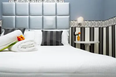 a bedroom with a white bed with a large headboard at The Cicer One in Rome