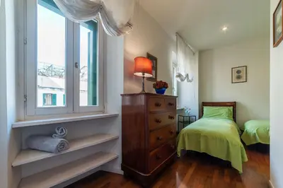 a bedroom with a bed and a dresser and a window at Colosseum - Charme Holidays in Rome