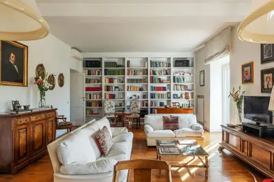 a living room with two white couches and a tv at Colosseum - Charme Holidays in Rome