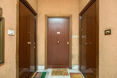 a hallway with two brown doors and a sign on the floor at LALY LOVE in Rome
