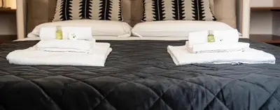 a bed with two stacks of towels and a couch at Domus Colosseum by JFM - Cozy apartment nearby Colosseum in Rome